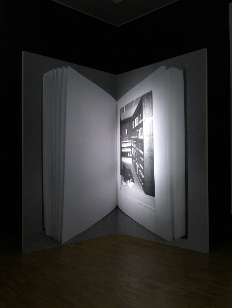 A student at ease among the books, 260 cm x 328 cm, b&w prints on wood, 2013<br />installation view Kumu Art Museum Tallin